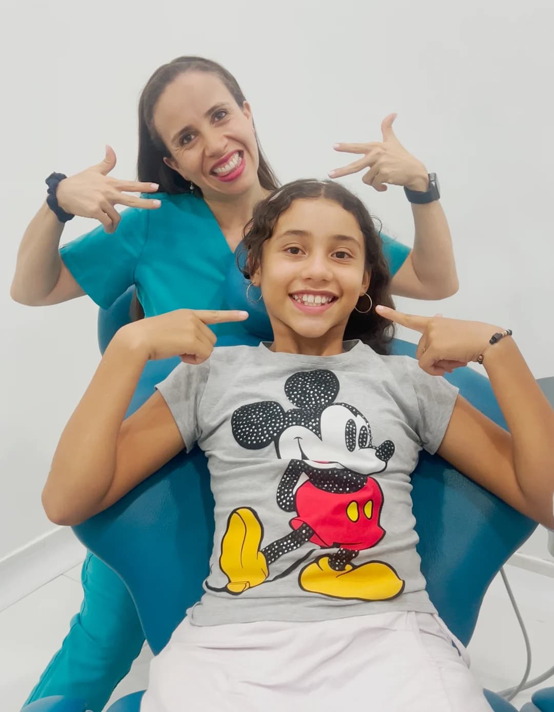 La Dra. Angie Lezama y una niña sonríen juntas en el consultorio.